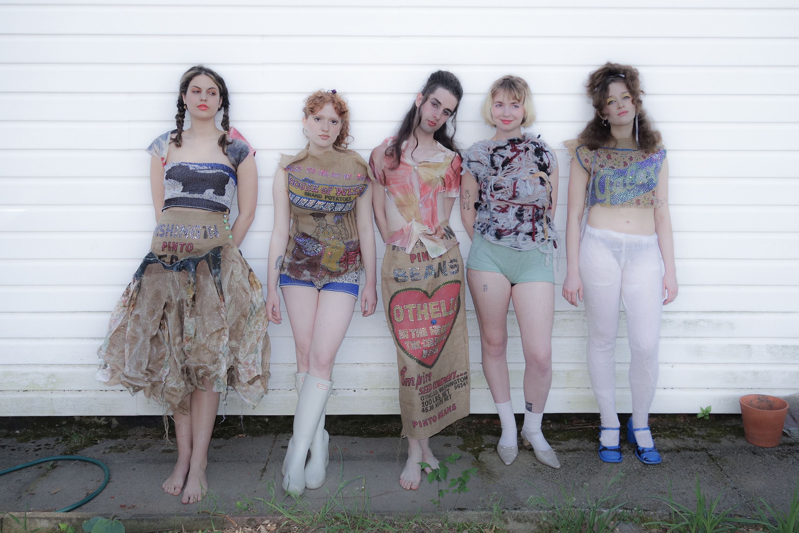 5 models stand against a wall in garments inspired by the American Midwest