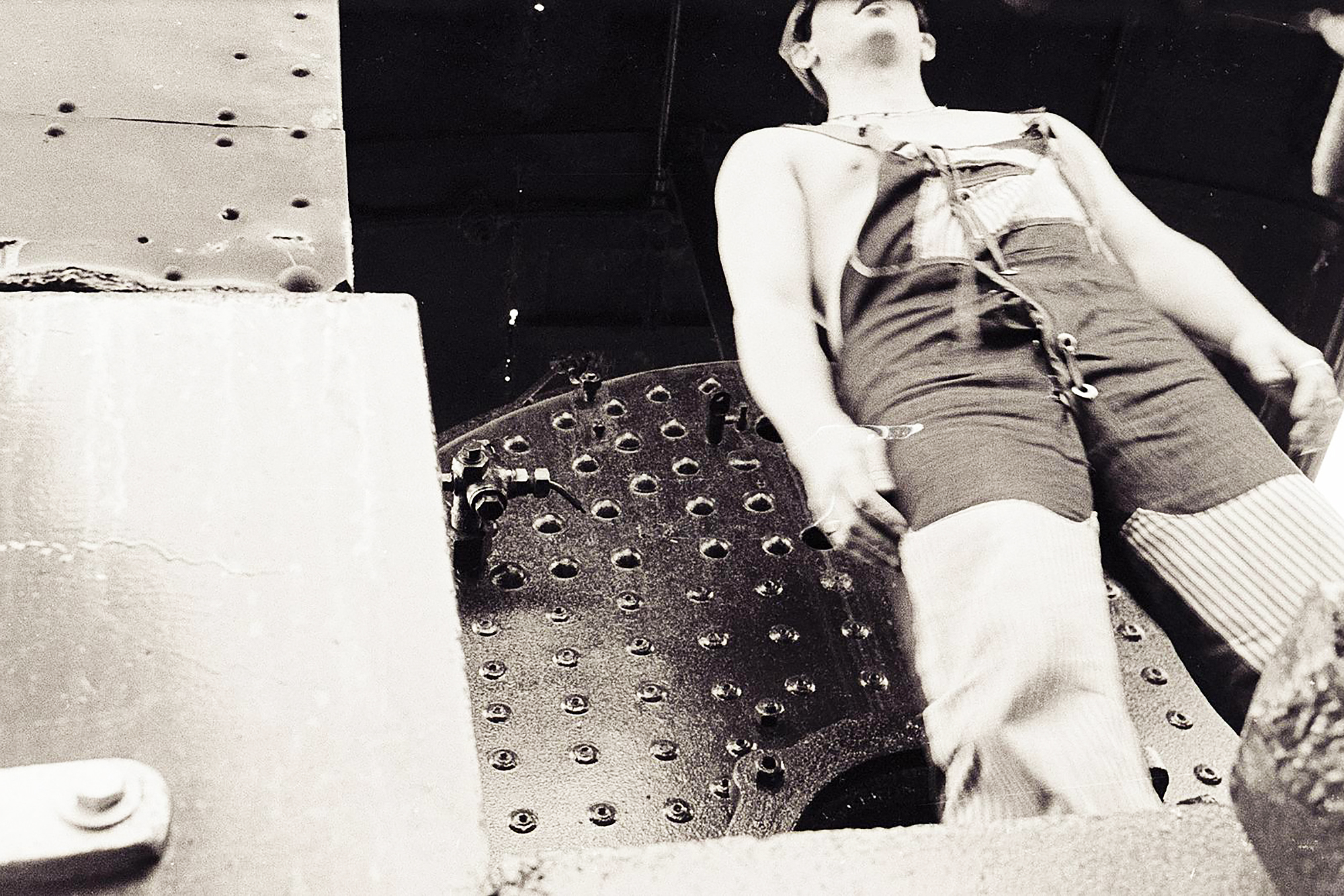 sepia-toned still of an old-timey train conductor from below