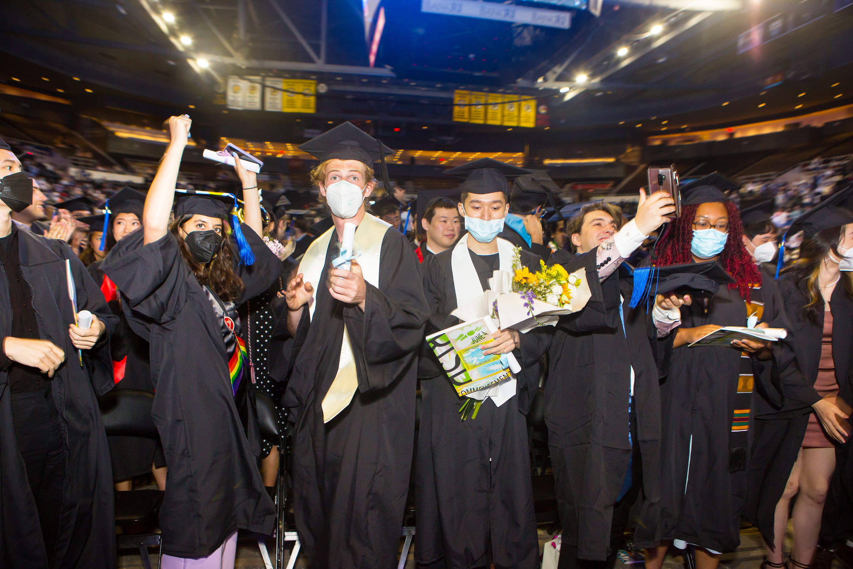 happy graduates in caps and gowns