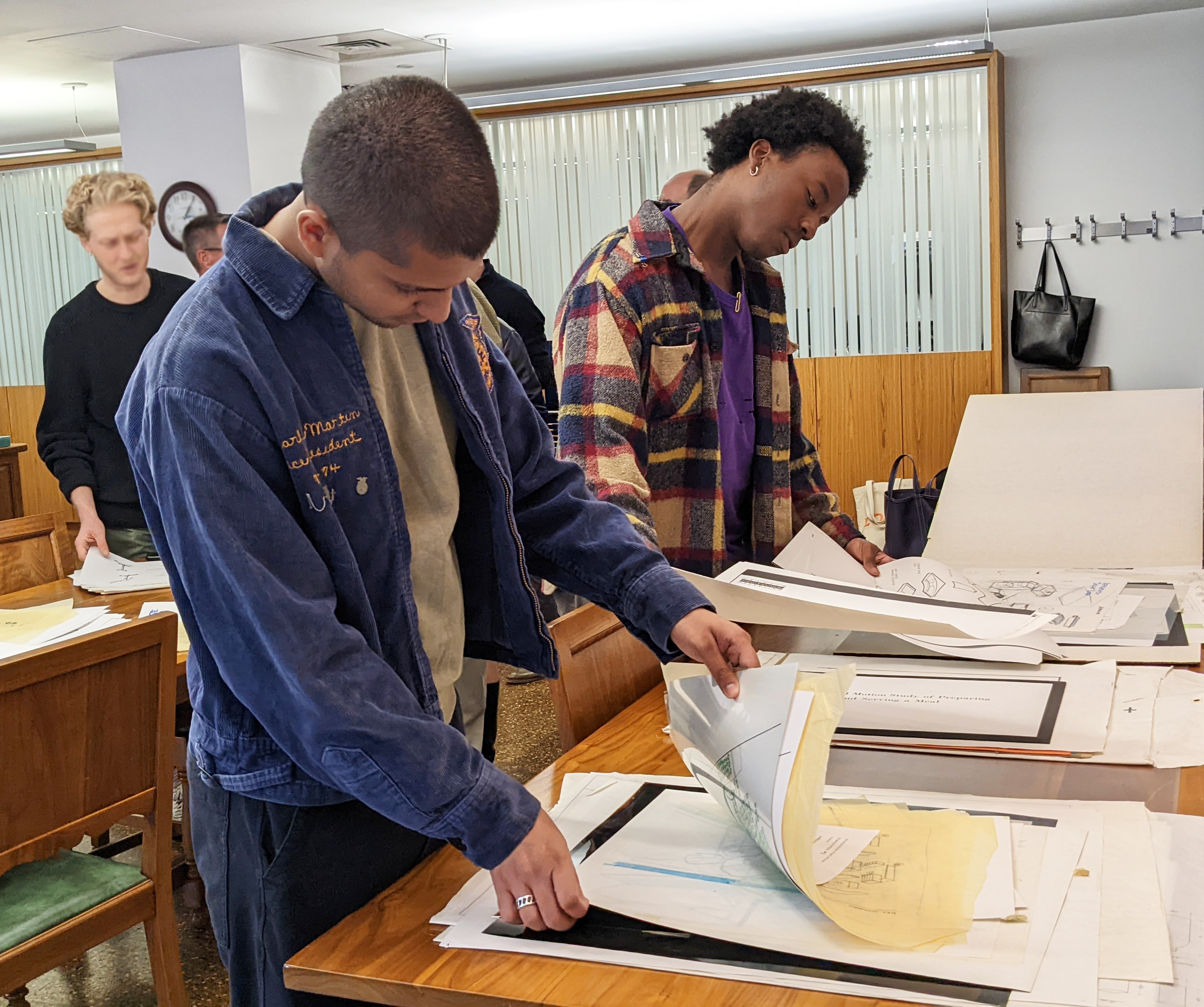 students pore over Universal Kitchen designs from the 1990s