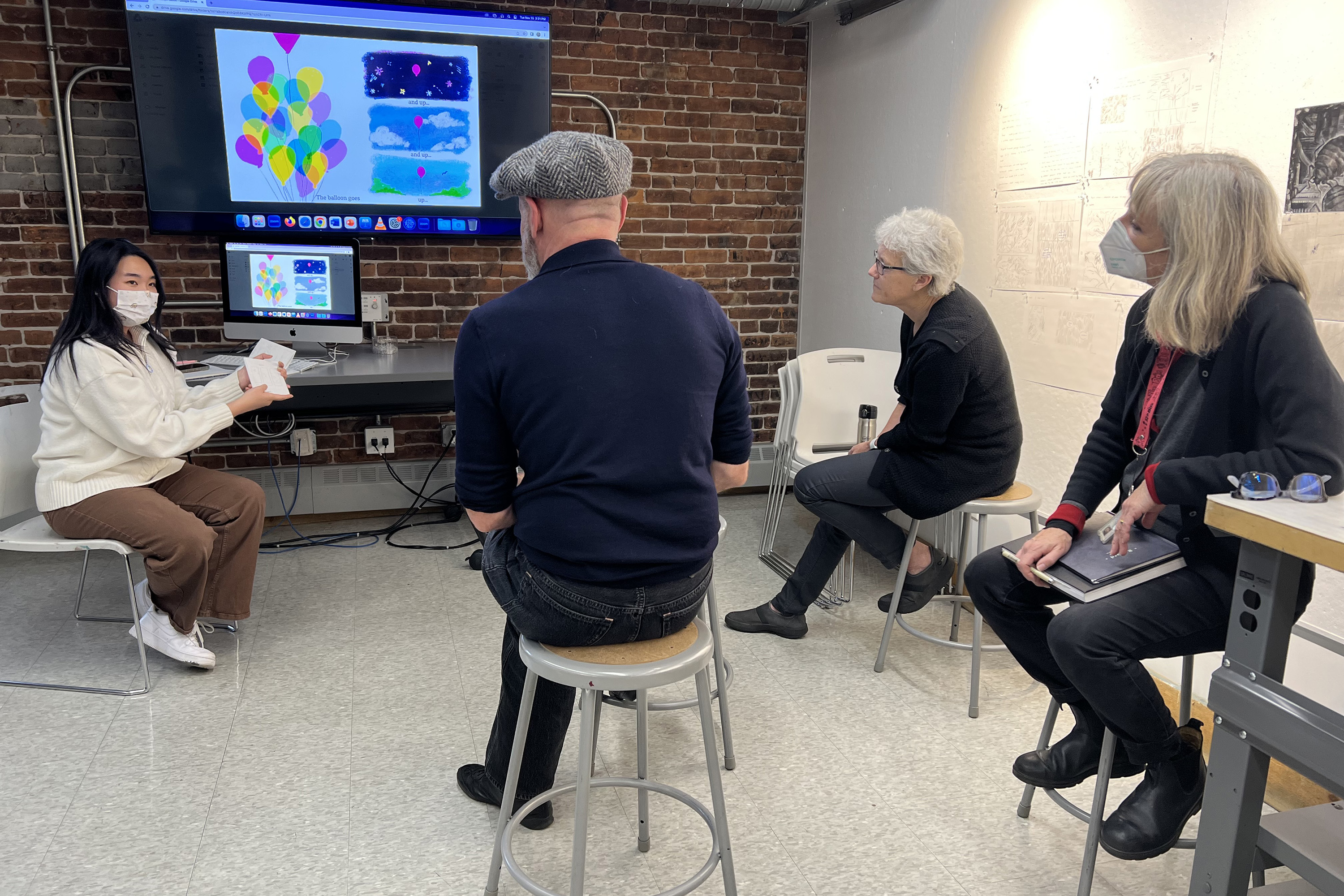 Jocelyn Salim presents on-screen work to Ford and faculty members