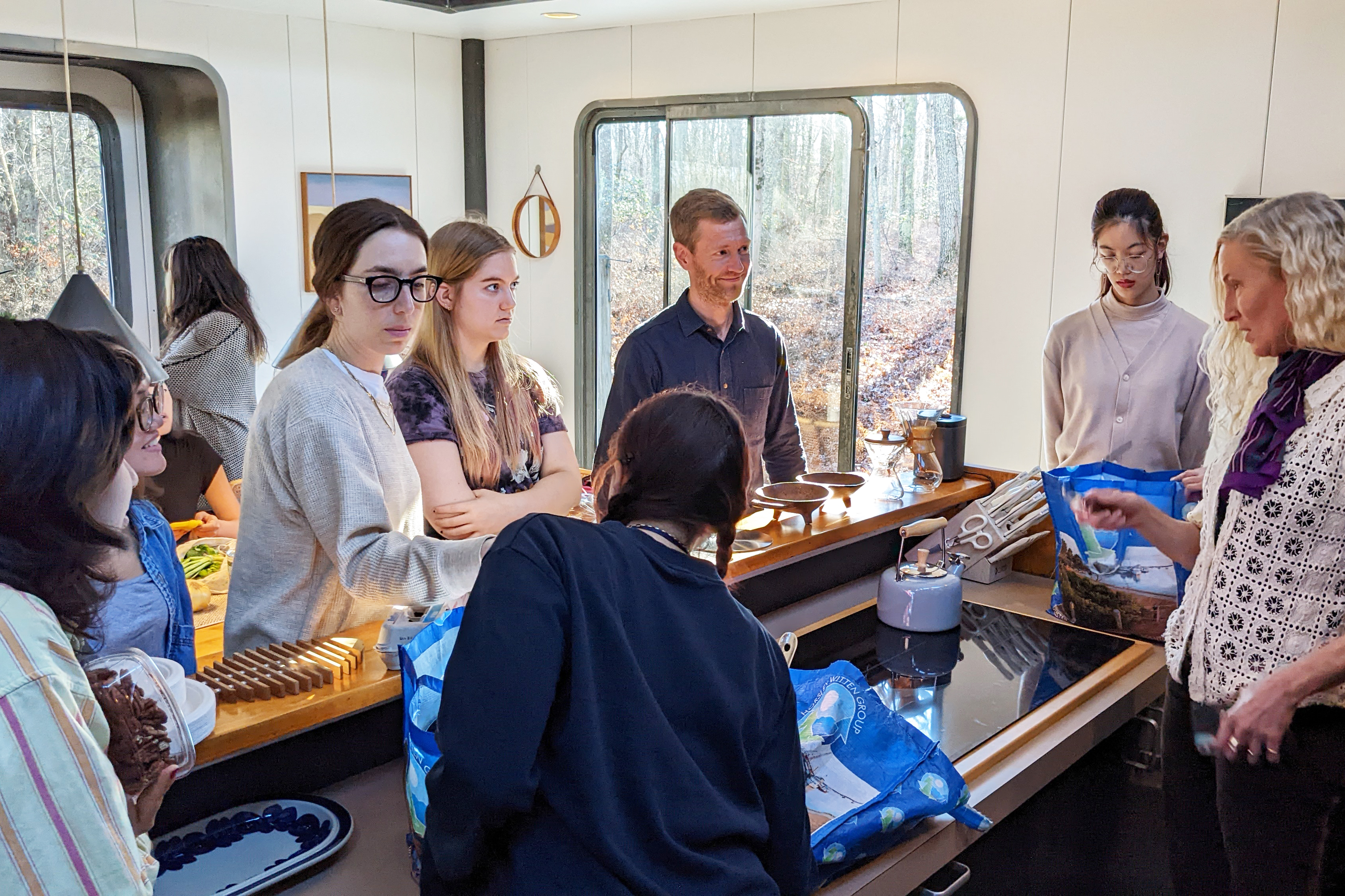 students and Eric Anderson gather in the kitchen
