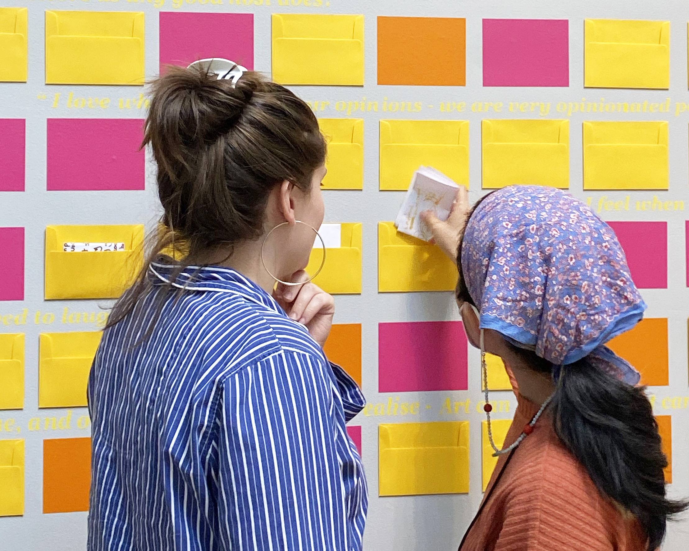 visitors interact with wall installation