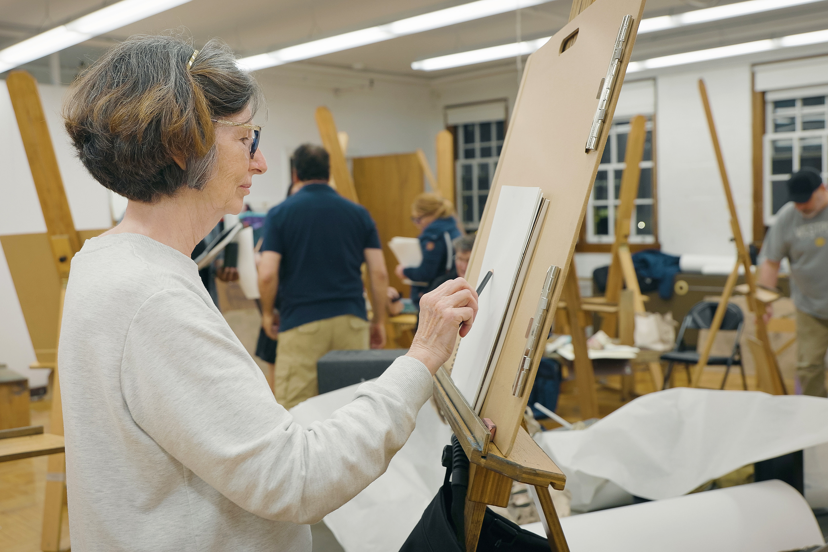 a woman begins a piece in a live Drawing course