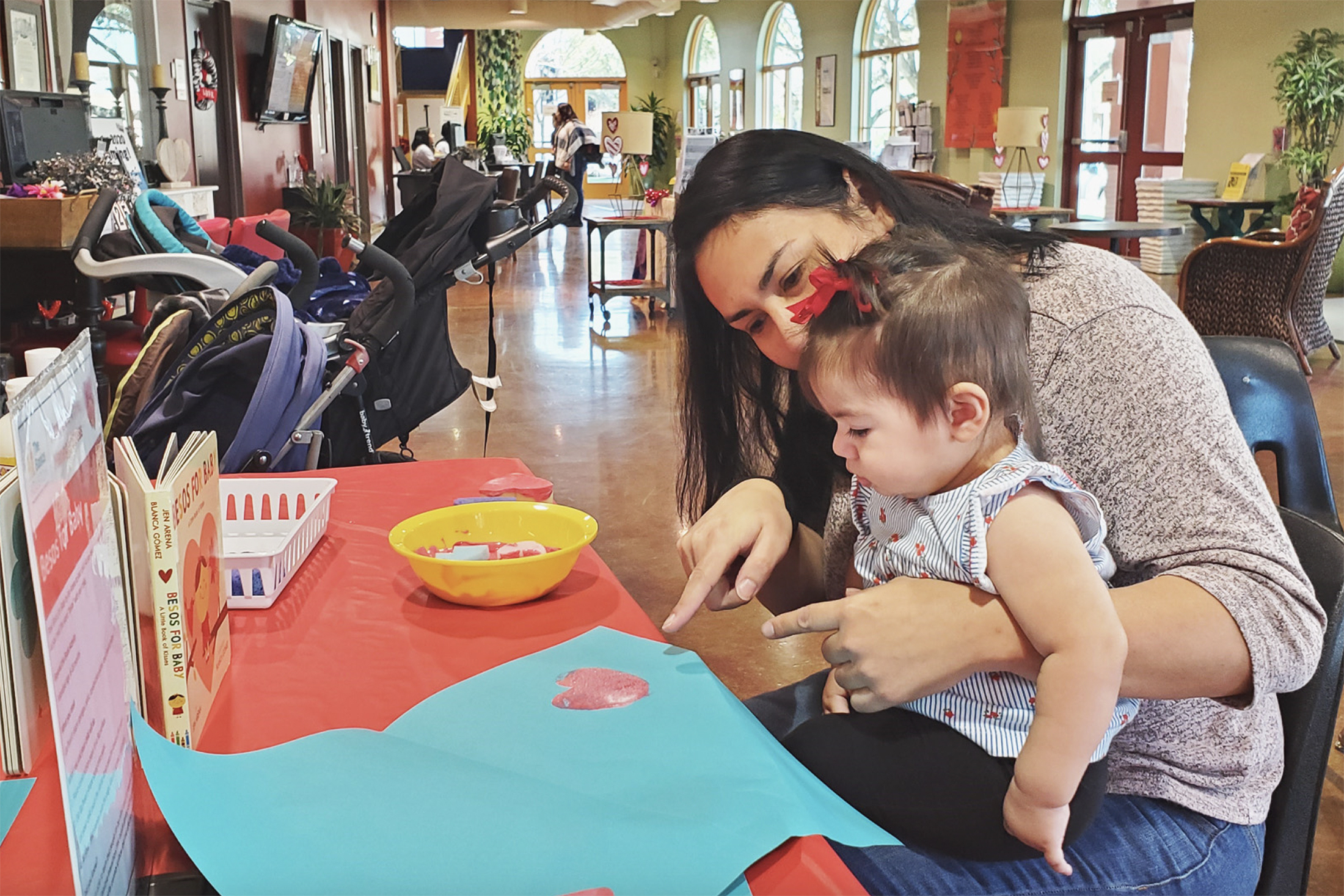 a mother uses pointing to stimulate the brain of her young toddler