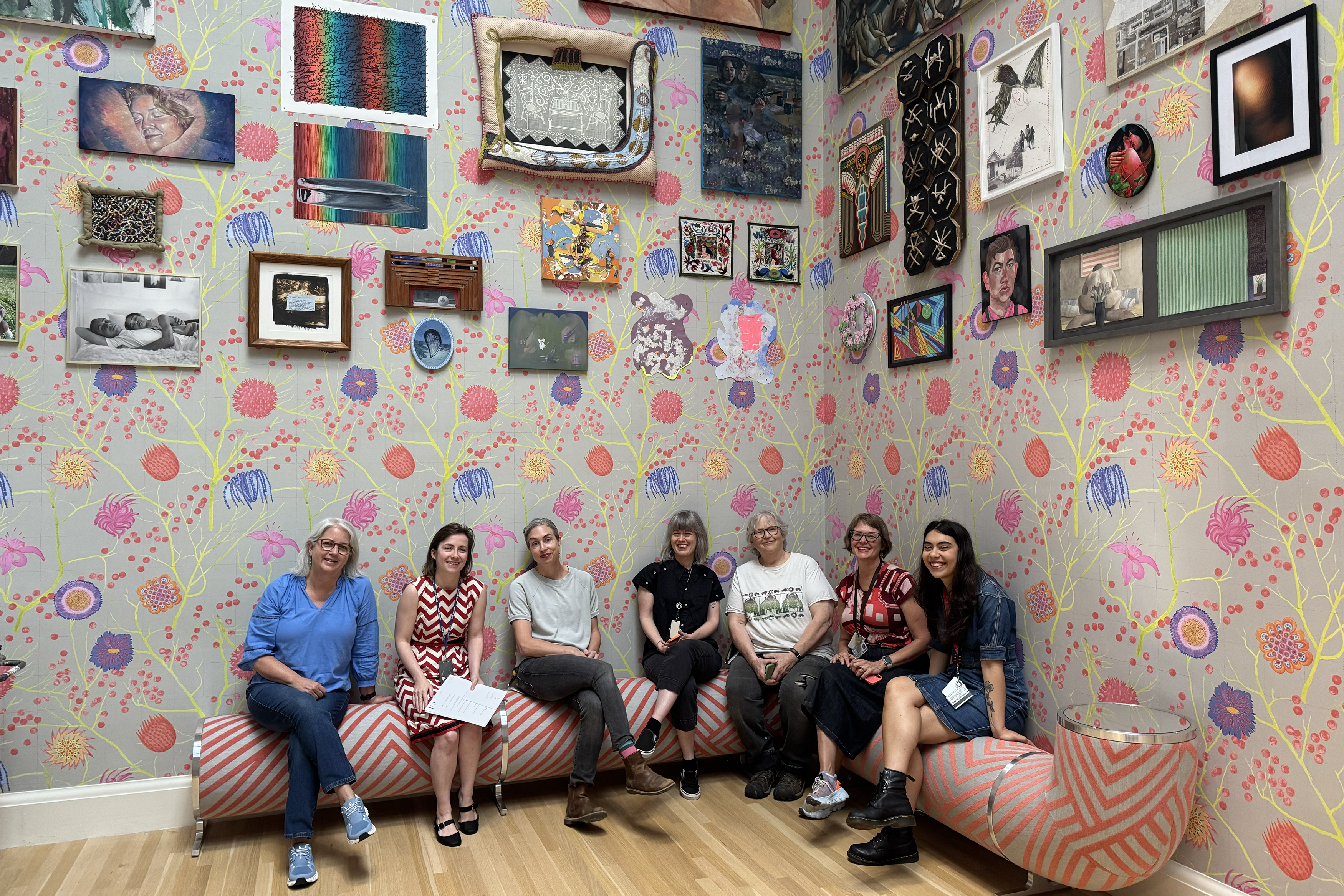 show curator and team of installers pose in the gallery