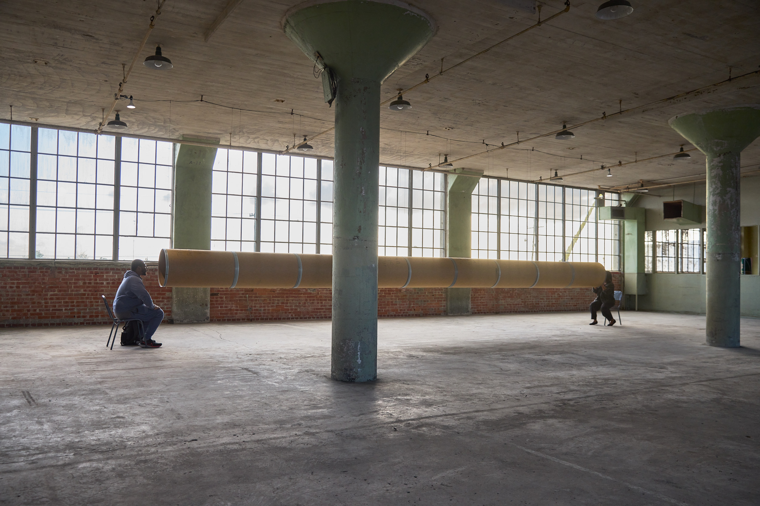 Kelley-Ann Lindo project inside a large empty warehouse