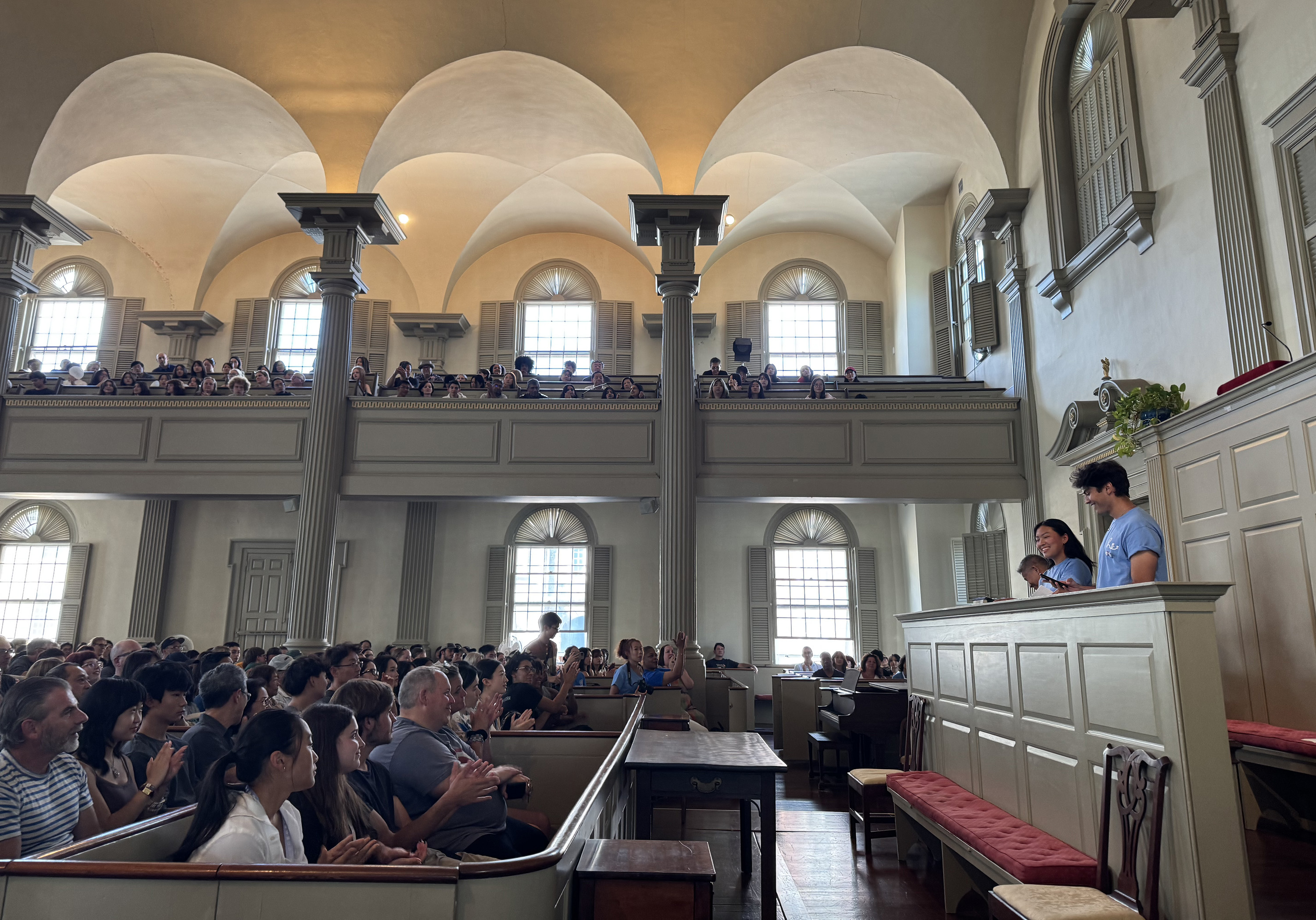 student volunteers address new students and their families in the First Baptist Church in America