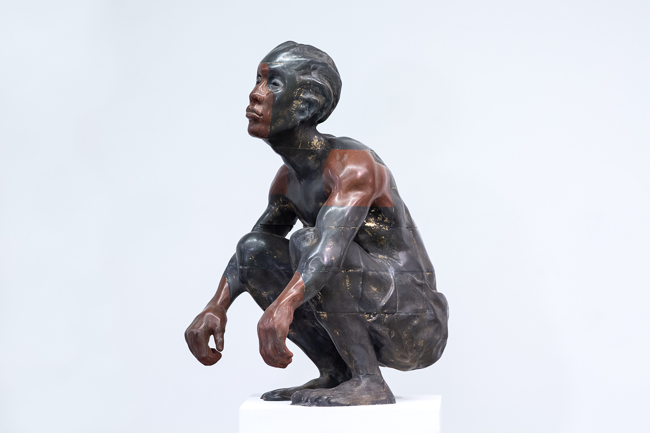 metal sculpture of a man in a crouched position
