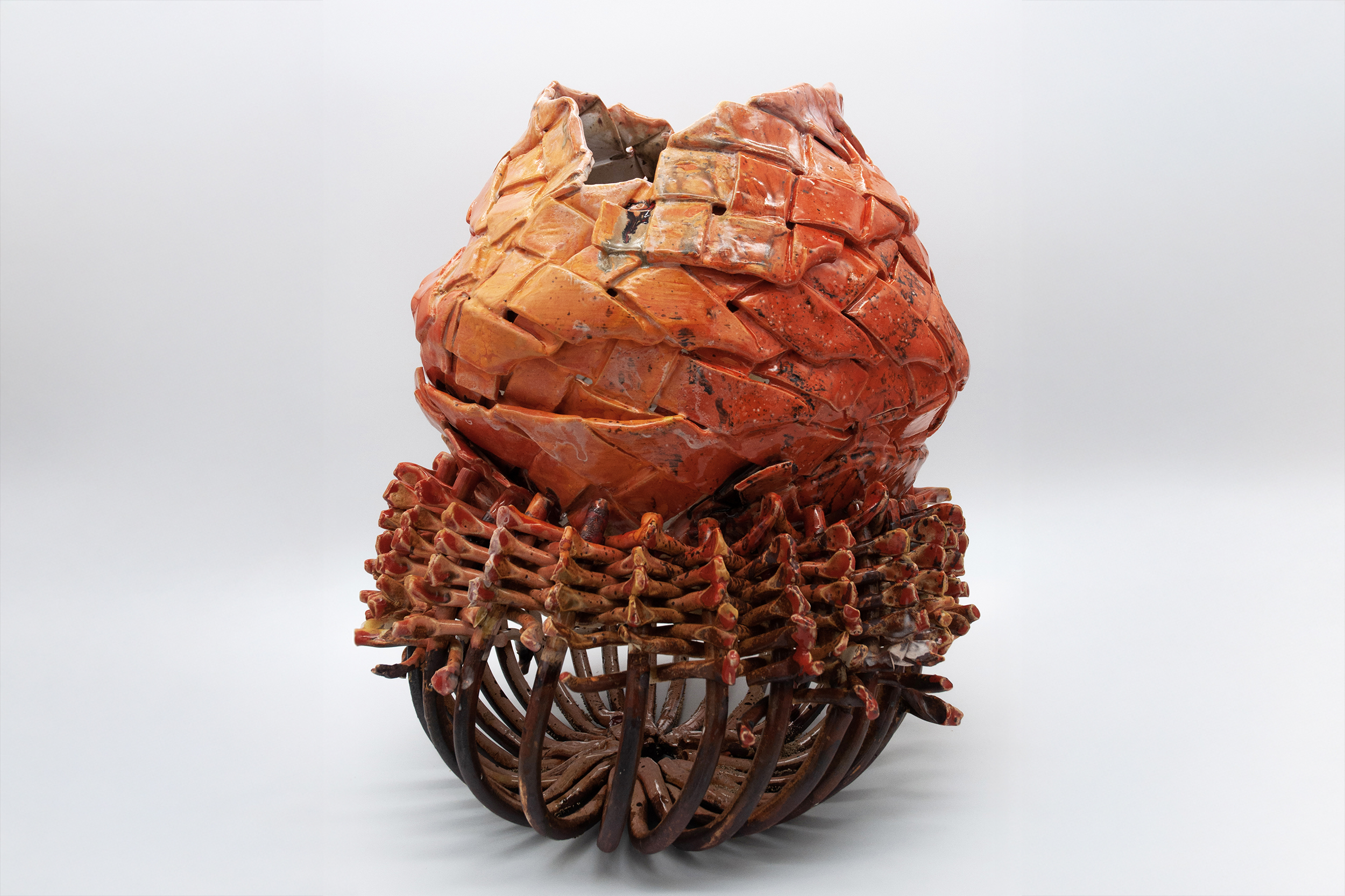 woven ceramic object in shades of orange and brown