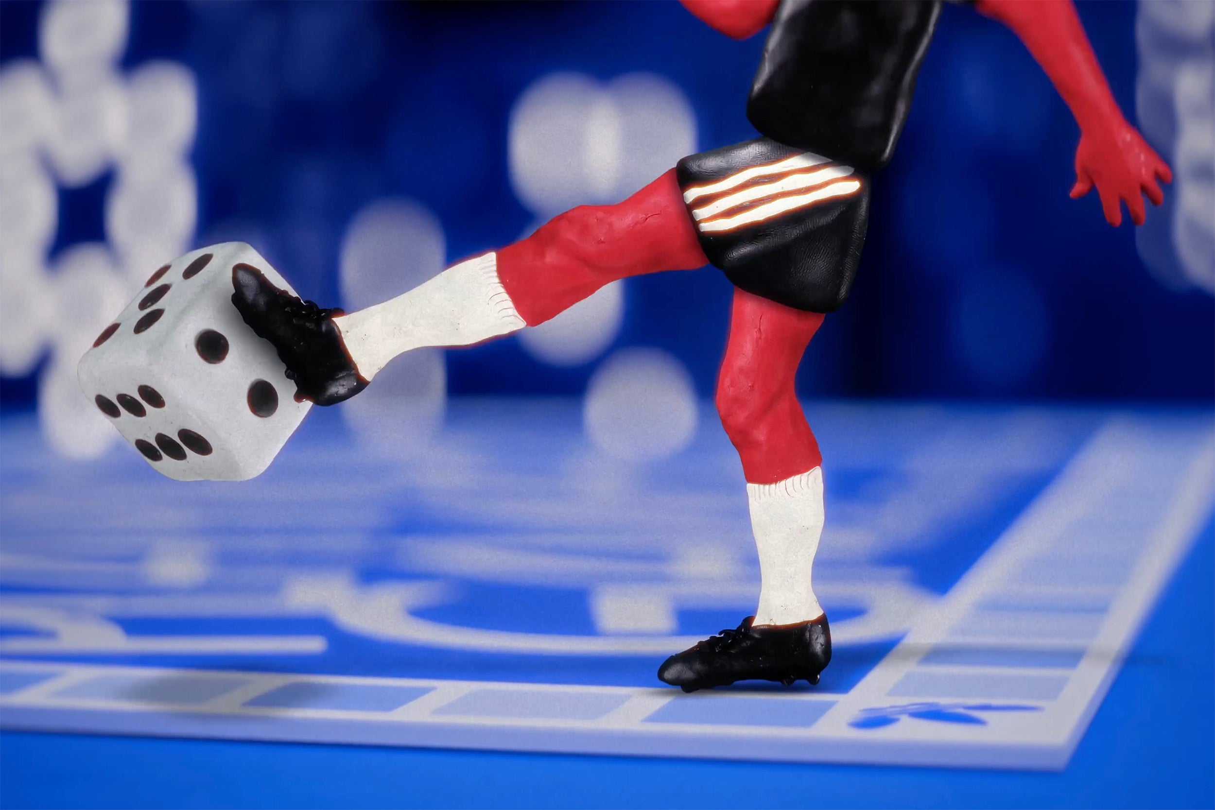 still of claymation soccer player kicking a die