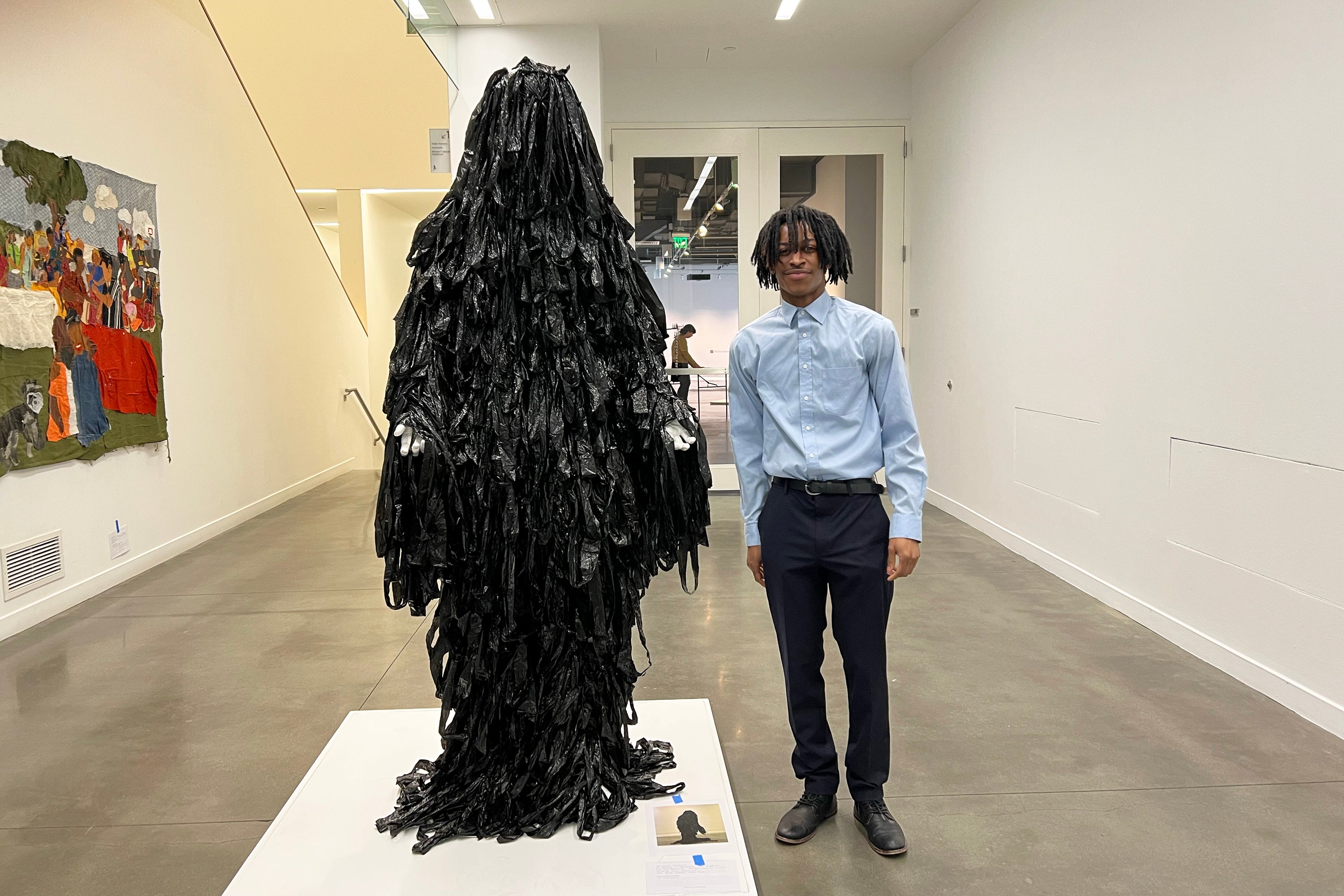 Khalil McKnight poses with his life-size figure in the gallery entrance