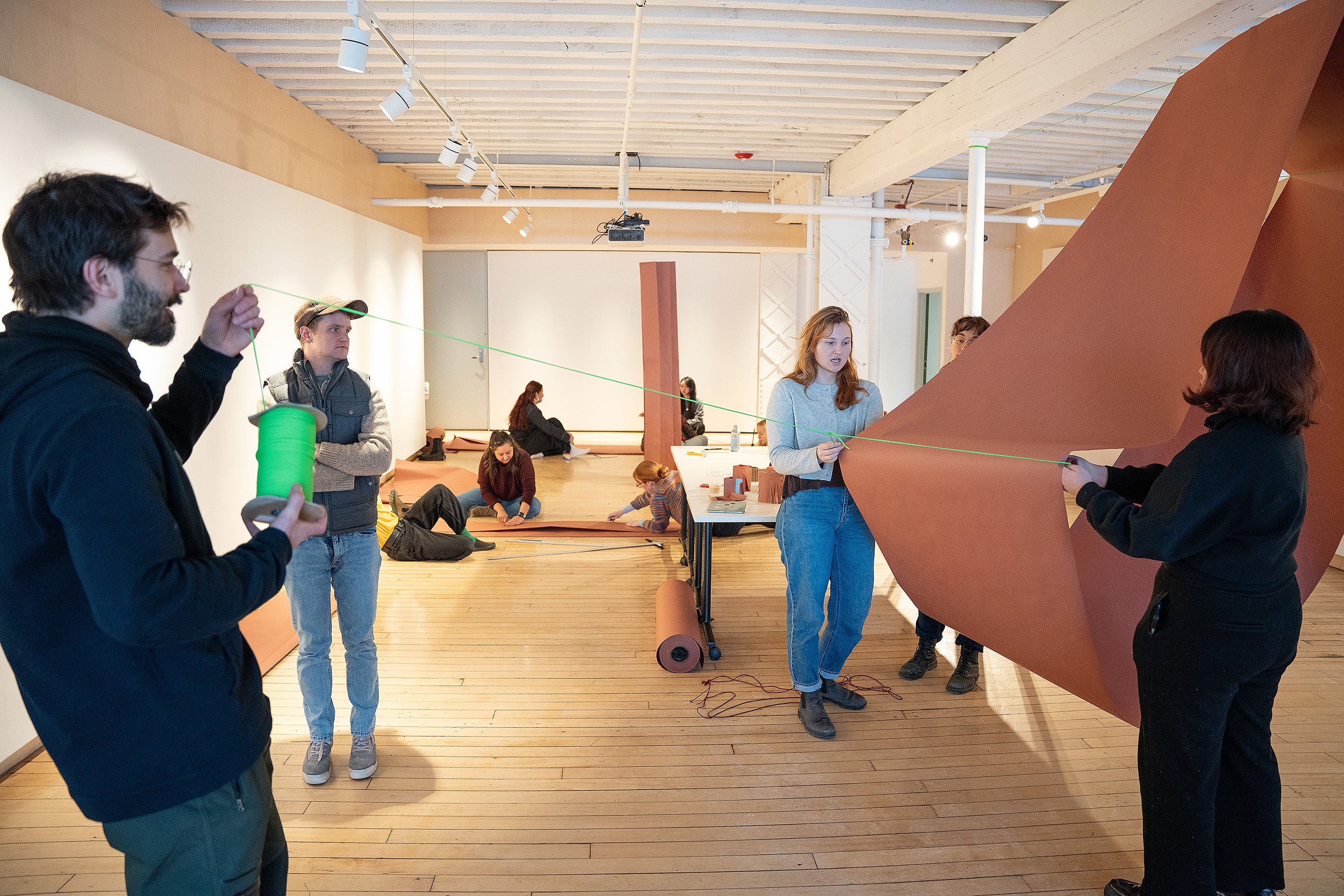 students working together to suspend paper structure from line