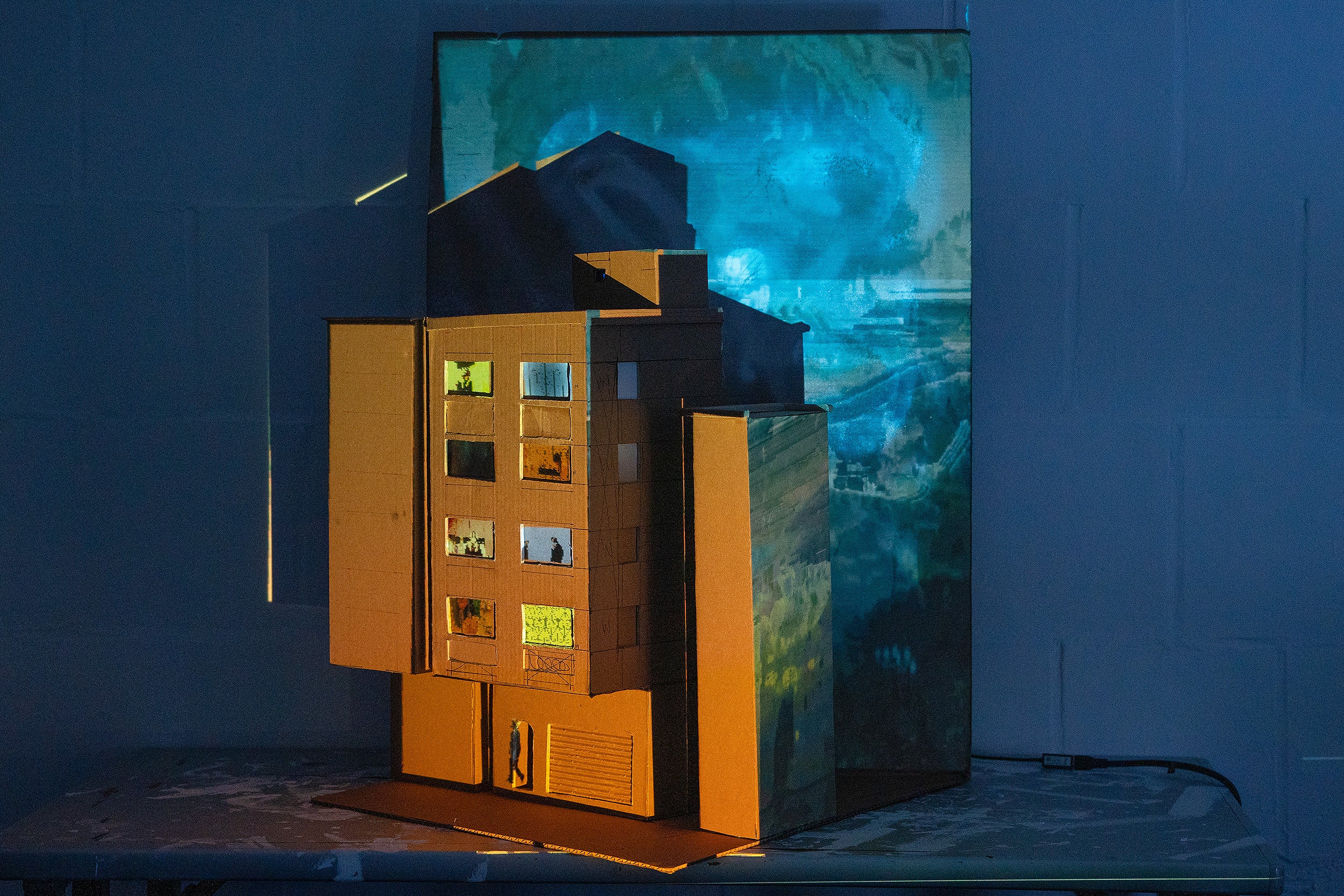 cardboard intallation of a city building with videos projected in all the windows