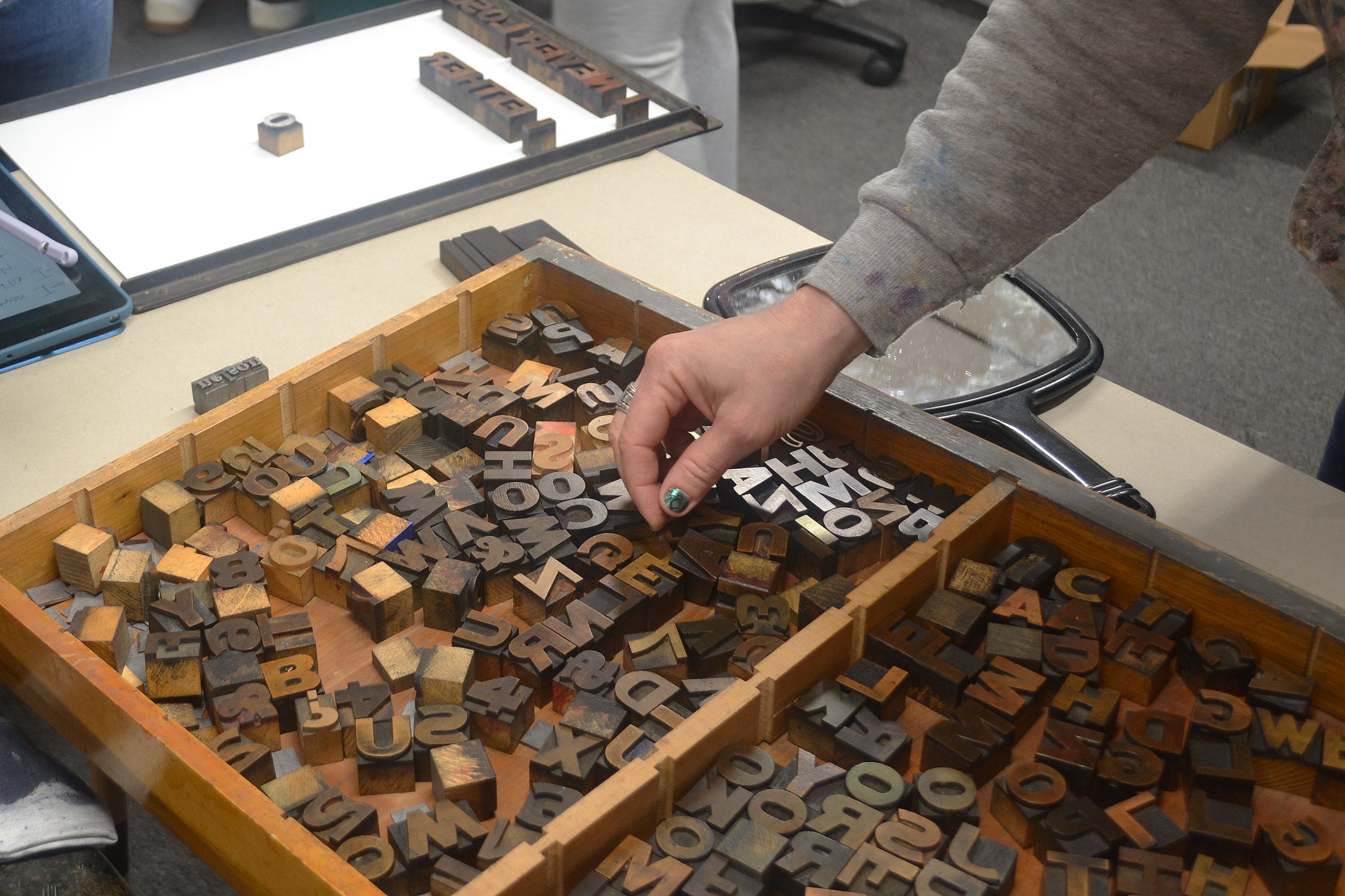 a participants selects letterpress letters from a box