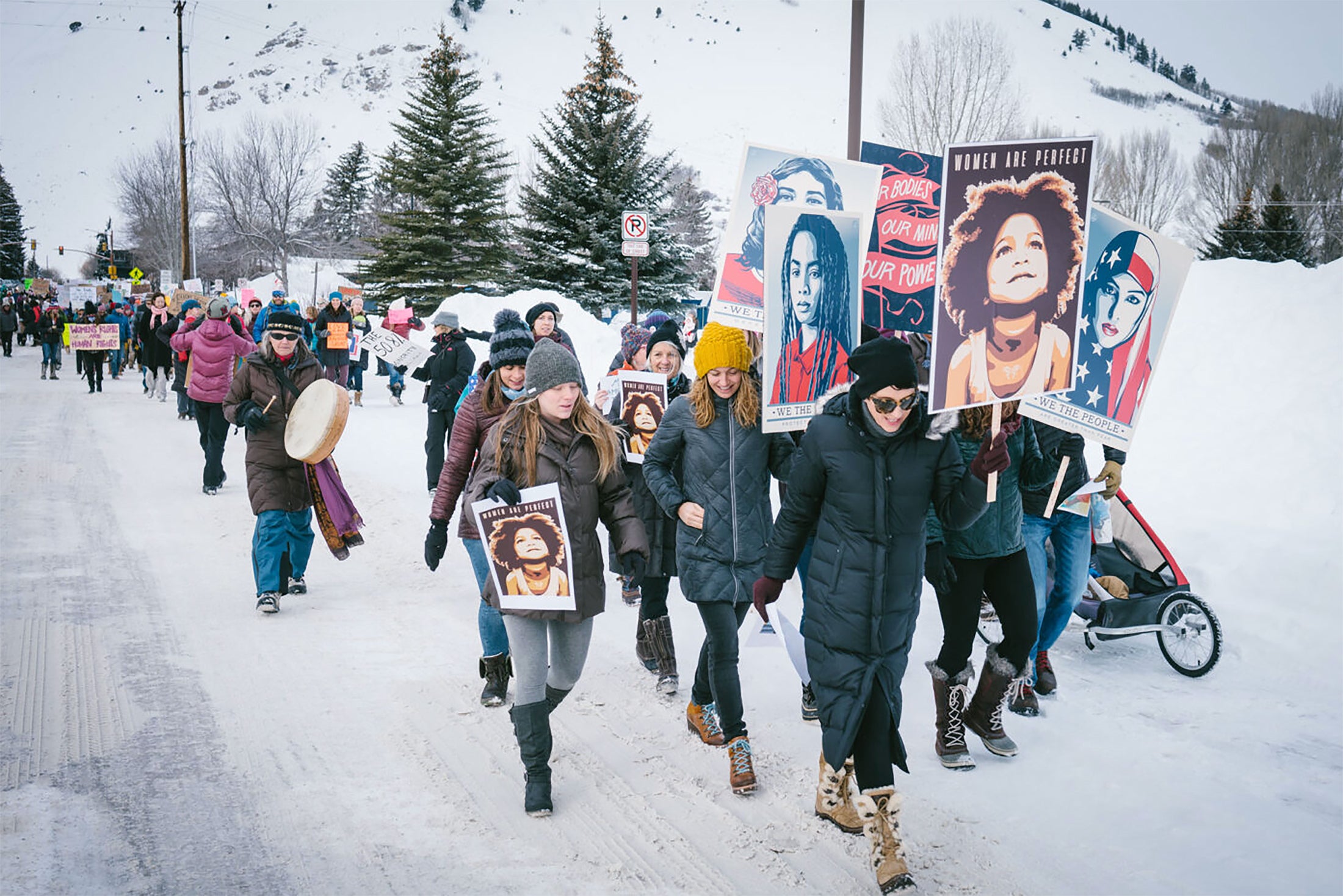 activists march for women holding Shepard Fairey posters distributed by Amplifier