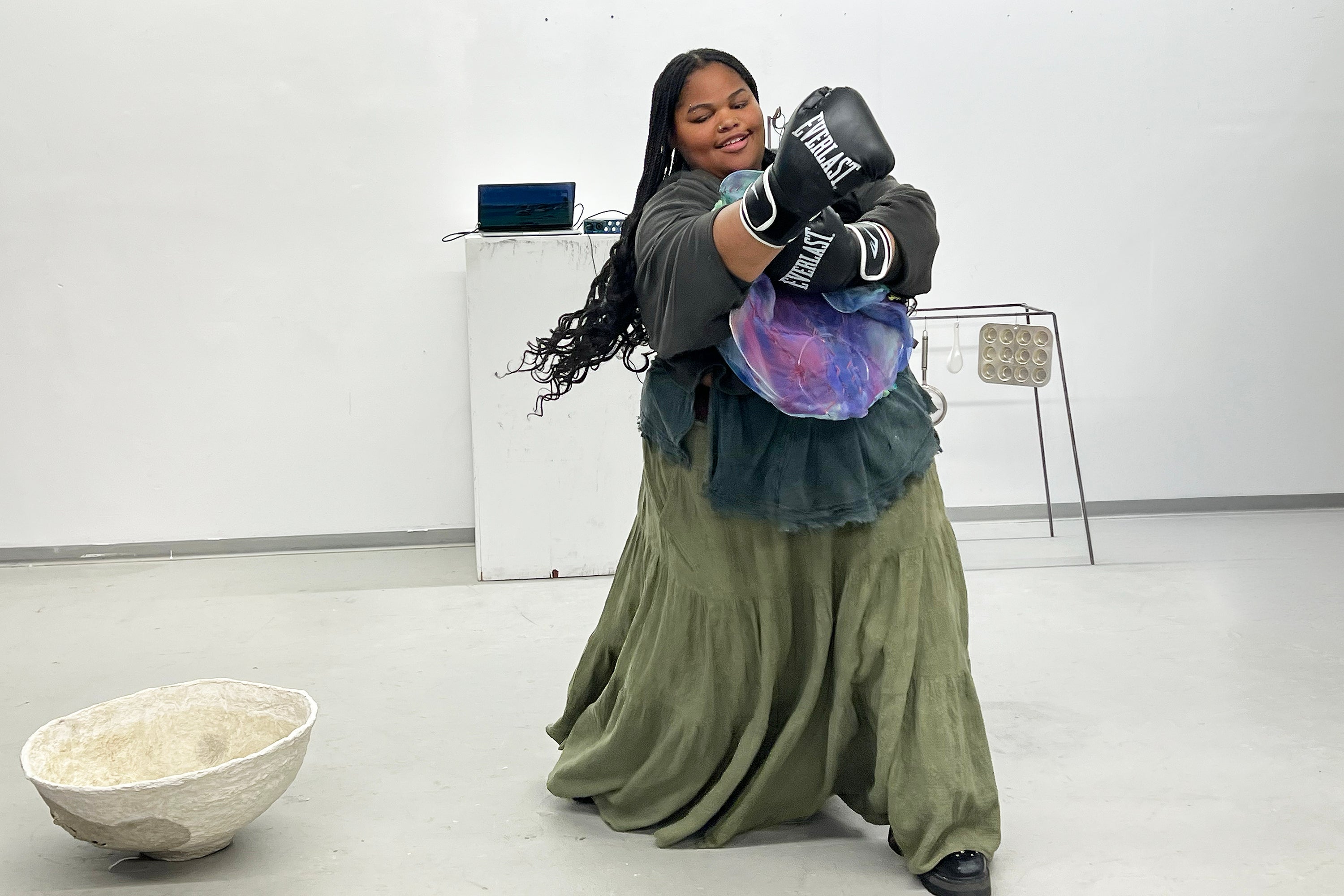 a student in a long skirt and boxing gloves demonstrates the notion of constraint