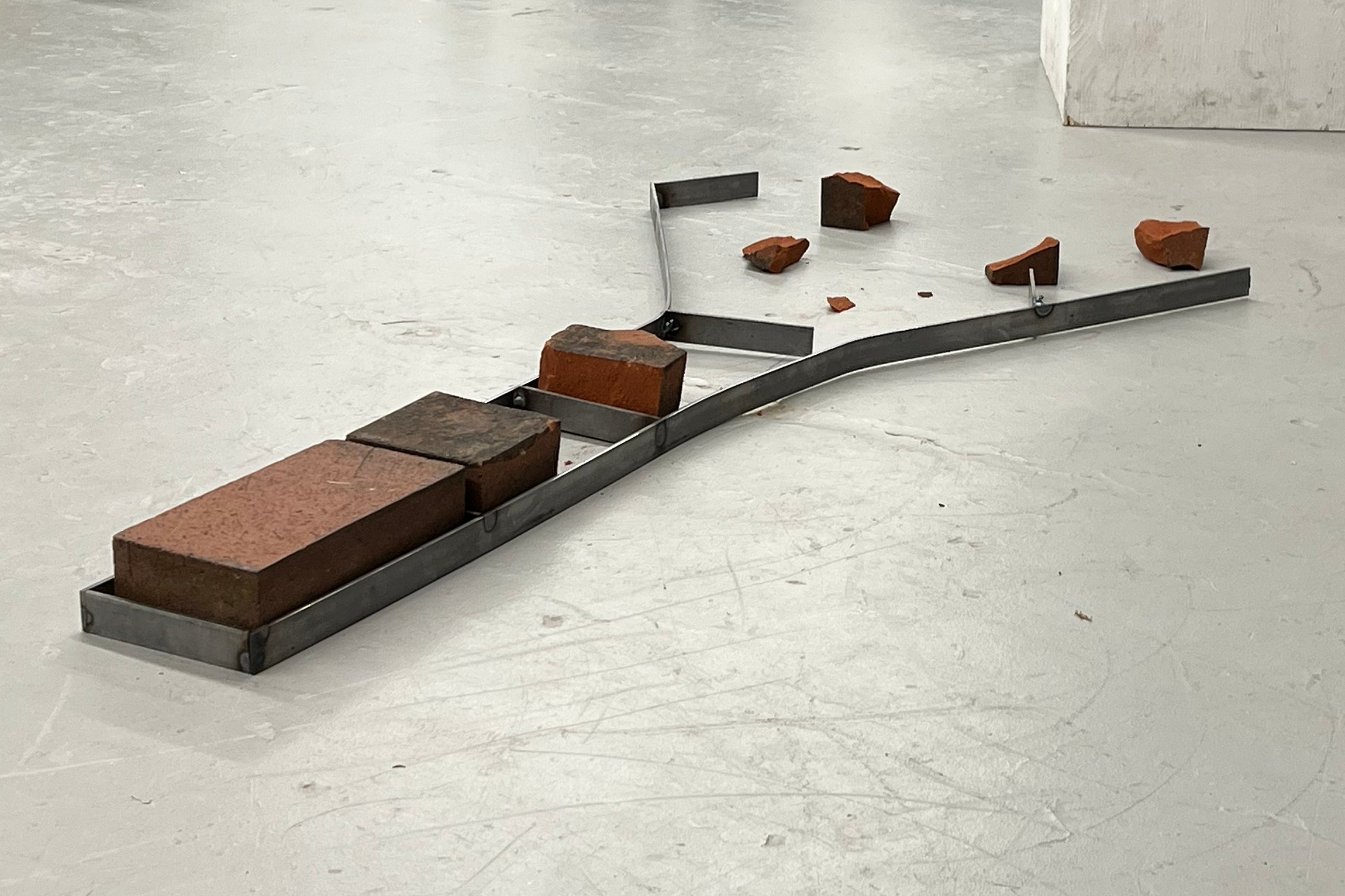 student project featuring a steel frame surrounding broken bricks