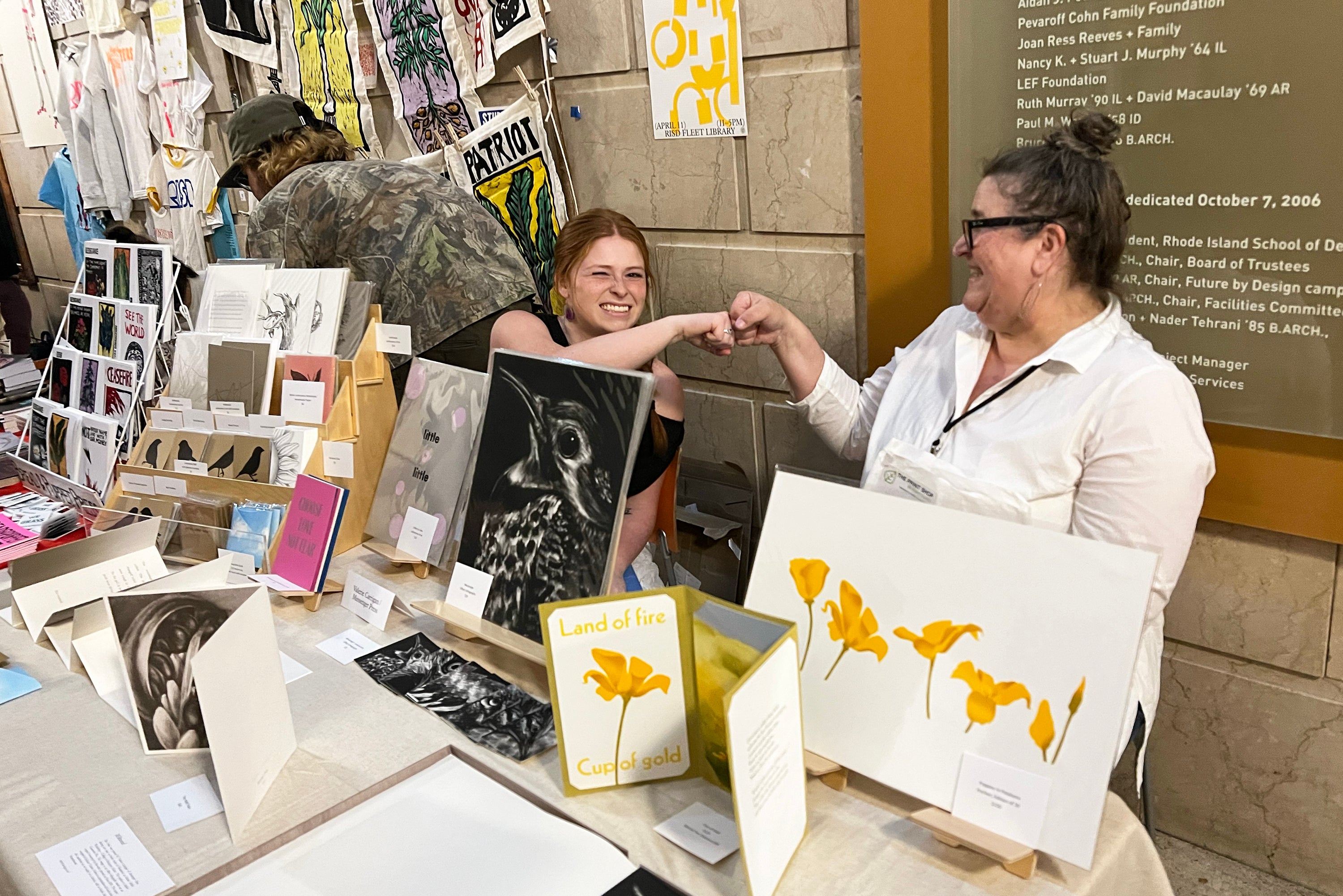 student and professor exhibitors share a celebratory fist bump