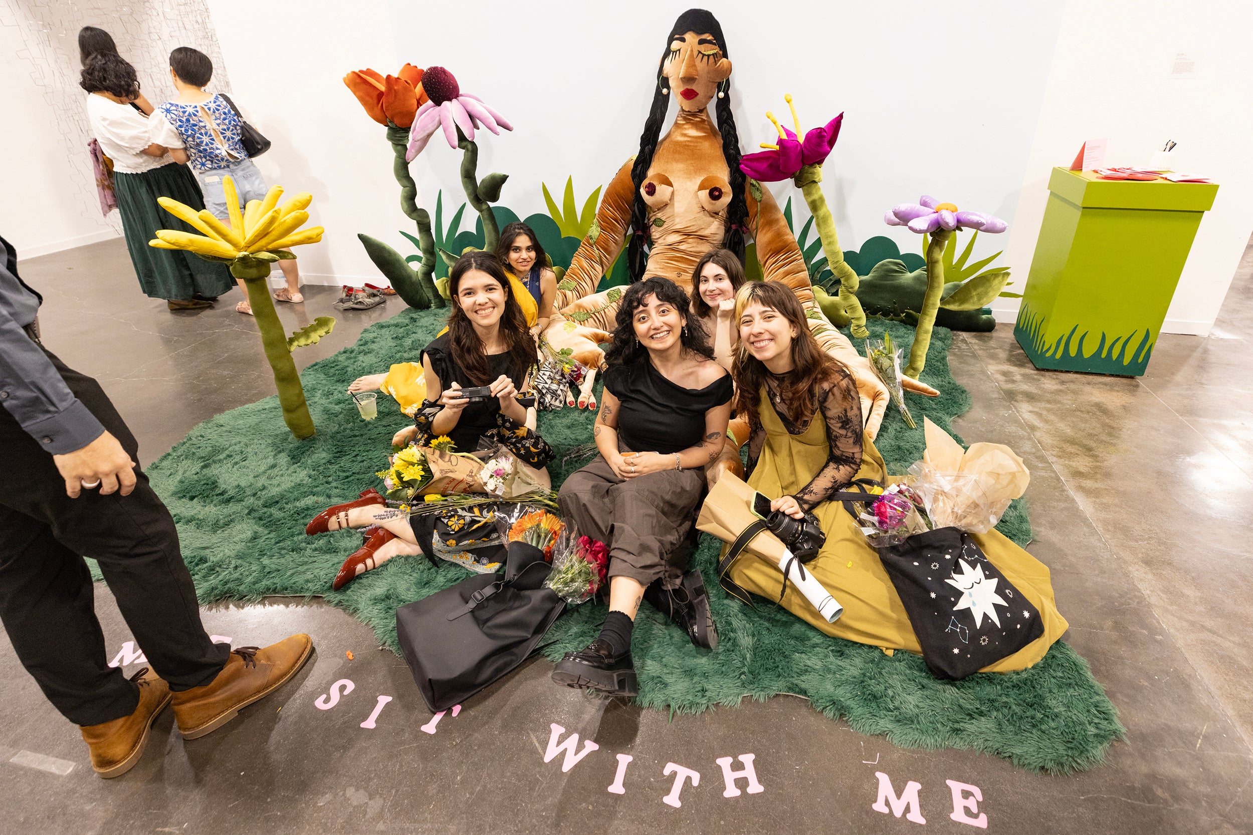 happy grads pose with huge female textile person