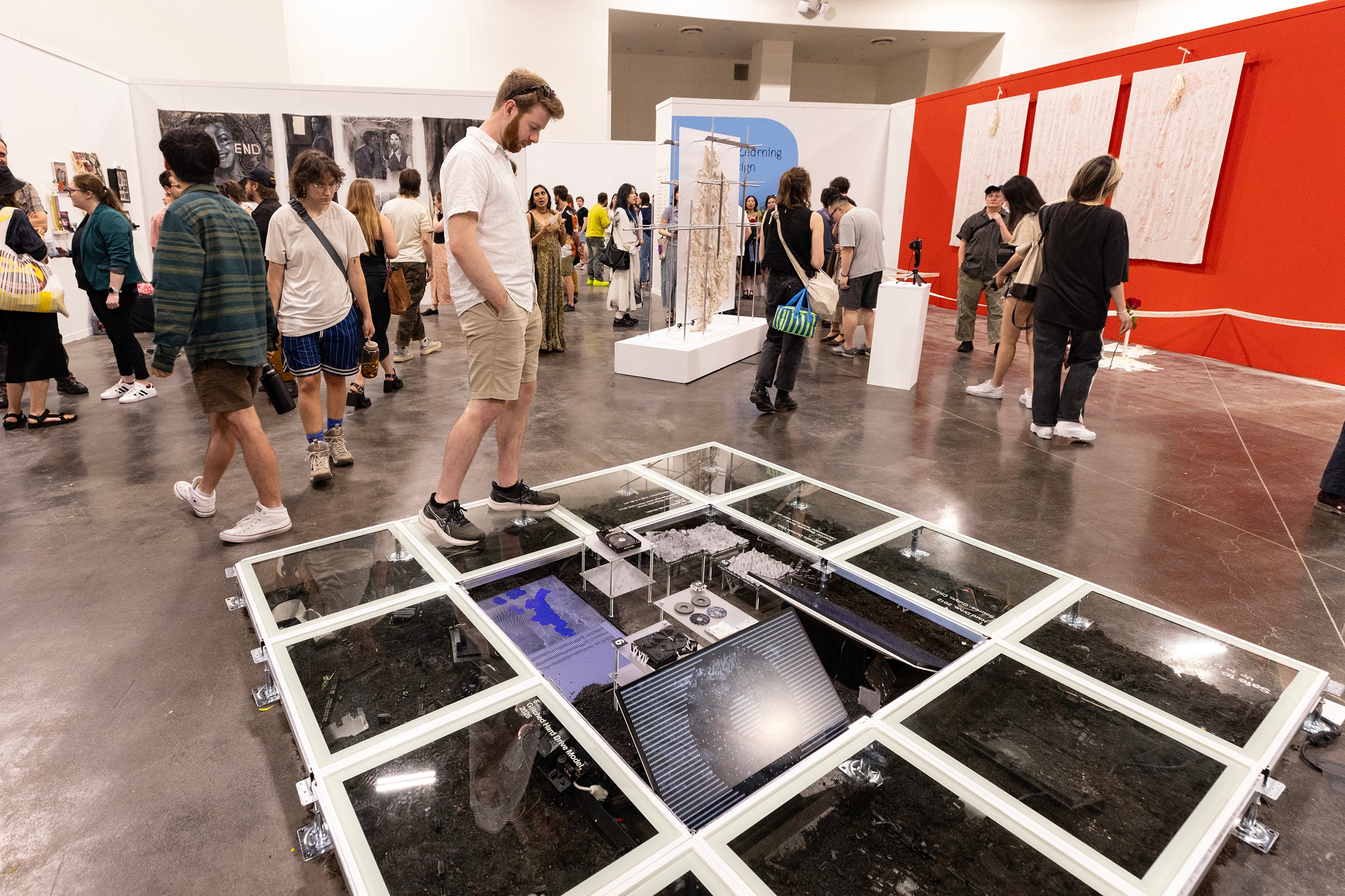 a visitor stands on a floor-mounted exhibition about soil and landscape
