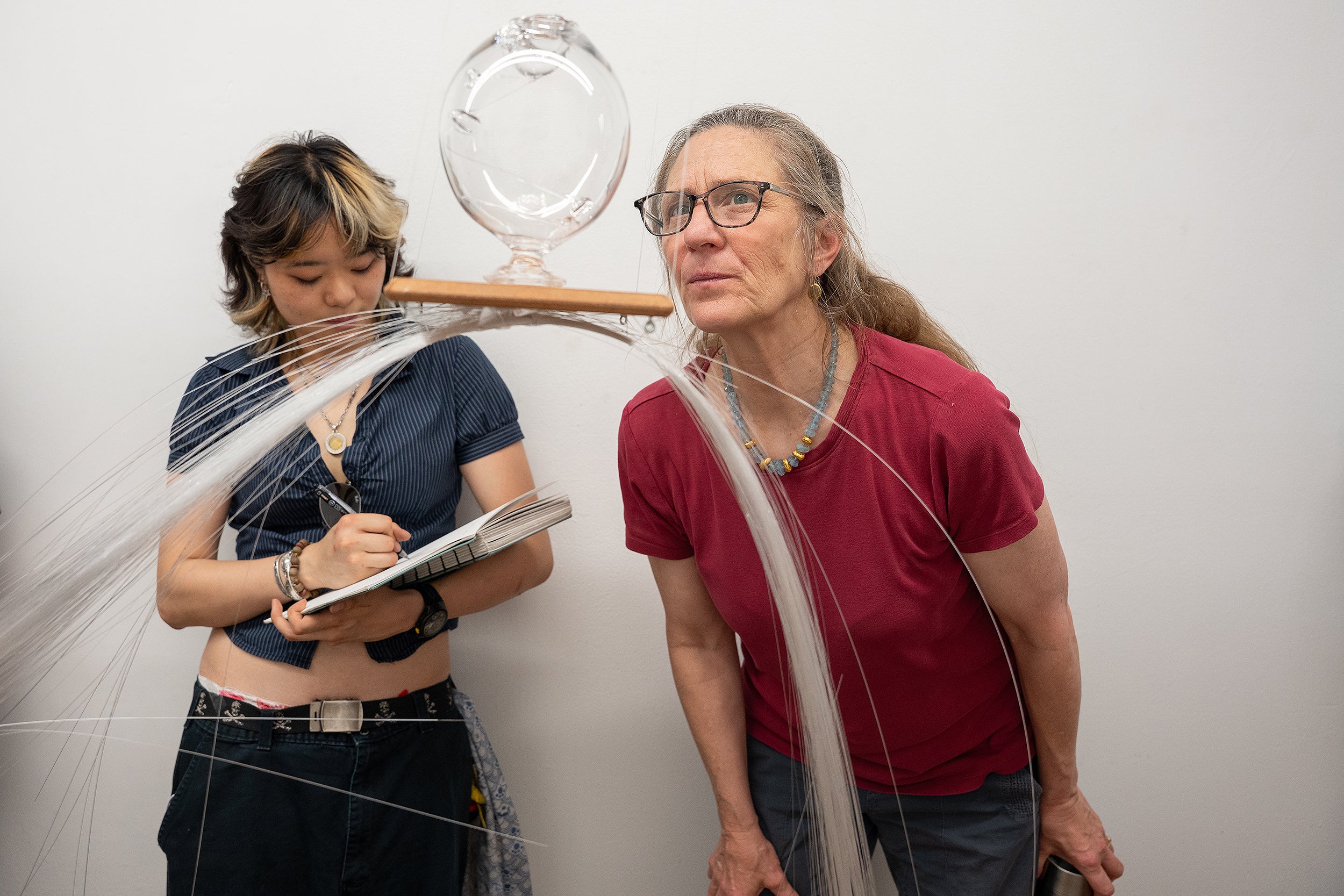 Glass Department Head Rachel Berwick examines a piece using glass threads