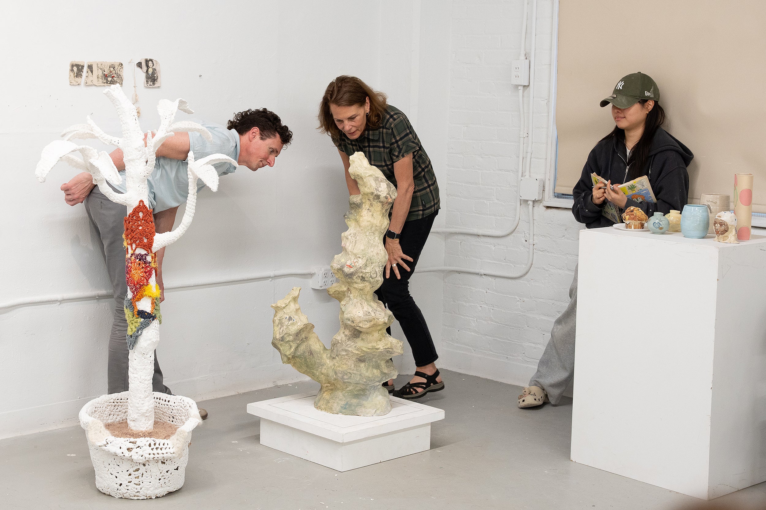 Ceramics faculty members lean in for a closer look at work by Wanxin Li 