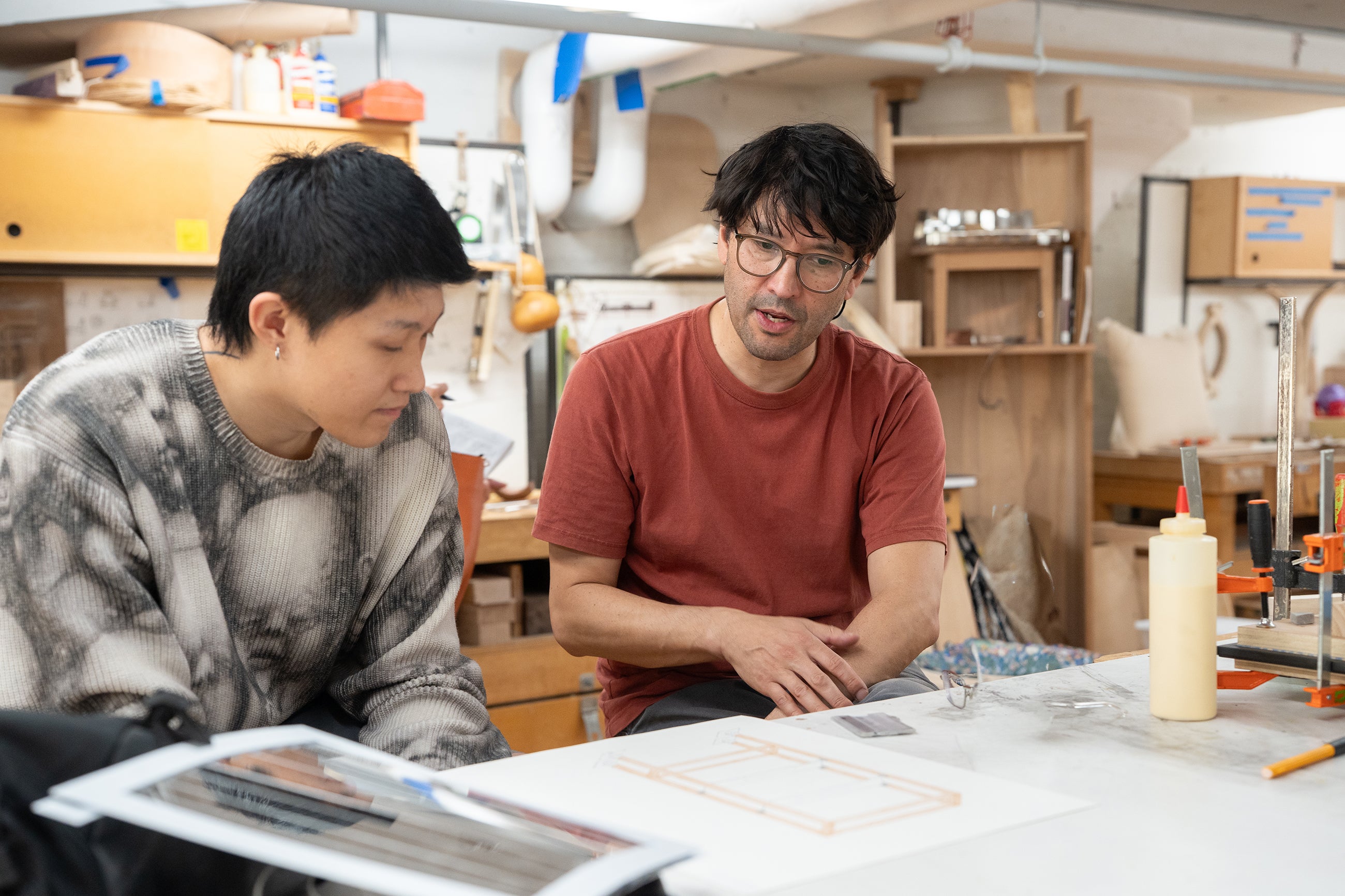 faculty member Jonah Takagi discusses a design with student