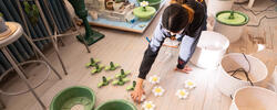 a student lays out parts to assemble a series of green-and-white, functional ceramic sculptures