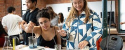 two students conduct biomaterial tests in a brick-walled studio-lab setting