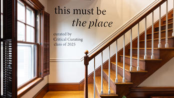 the words "this must be the place: curated by Critical Curating class of 2025" printed on a white wall behind a flight of stairs