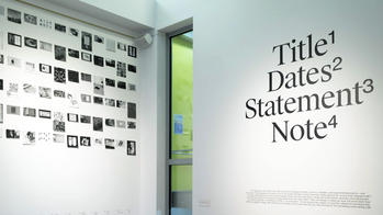 two gallery walls, with a series of black and white images on the left wall, and the words Title, Dates, Statement and Note on the right wall