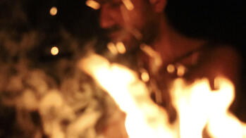 image of the artist, Tsohil Bhatia, behind a roaring fire