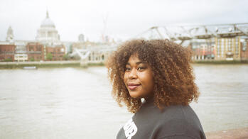 Donelle Wedderburn in front of a river and city scape