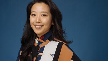 Headshot of Whitmire Vo in a patterned shirt against a blue background