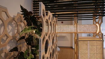 an interlocking set of geometrically crafted wood structures inside a gallery space