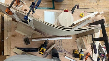 a piece of wave-shaped wood resting on its edge on top of a work table