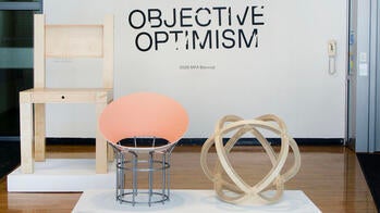 gallery entry with chairs and other objects on view