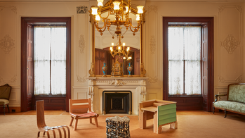 Contemporary furniture pieces arranged in the center of an opulent traditional parlor room