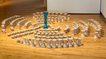 a group of ceramic vessels arranged in a circle on the gallery floor