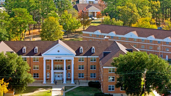 aerial view of college buildings surrounded by green trees