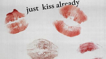 the words just kiss already and lipstick kisses on white