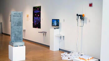 four art objects on display inside a gallery