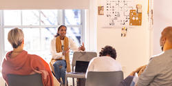 a graphic design student presents her work to a panel of critics