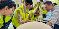 students in yellow safety vests visit an Urban Arts Project in progress