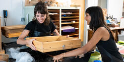 Two students make a sheet of paper