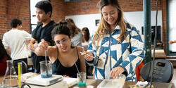 two students mix bioplastics on top of a hotplate