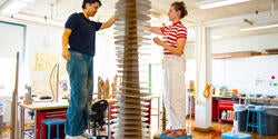 students work together on tall cardboard model