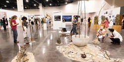 viewers crouch down to engage with work at Grad Show 2026