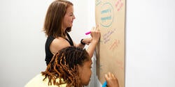 Teaching & Learning Lab workshop participants write ideas on a large piece of butcher's paper